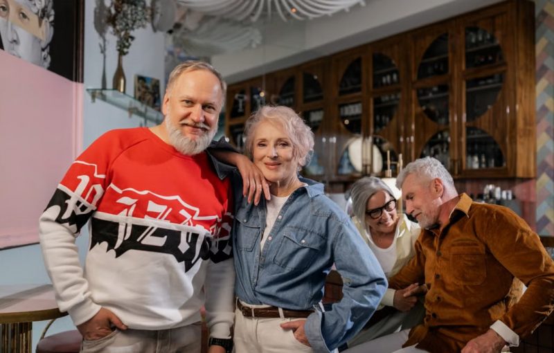 A joyful gathering of senior friends enjoying a pleasant time together in a cozy cafe setting.